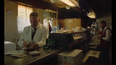 a man standing at a counter in a restaurant