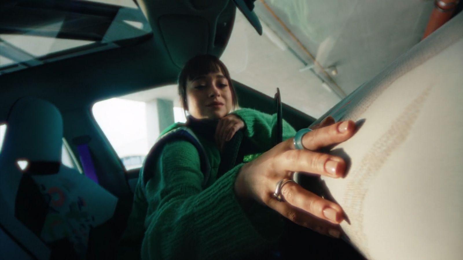 a woman sitting in a car writing on a piece of paper