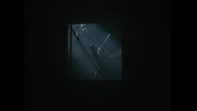 a woman standing in the dark holding a tennis racquet