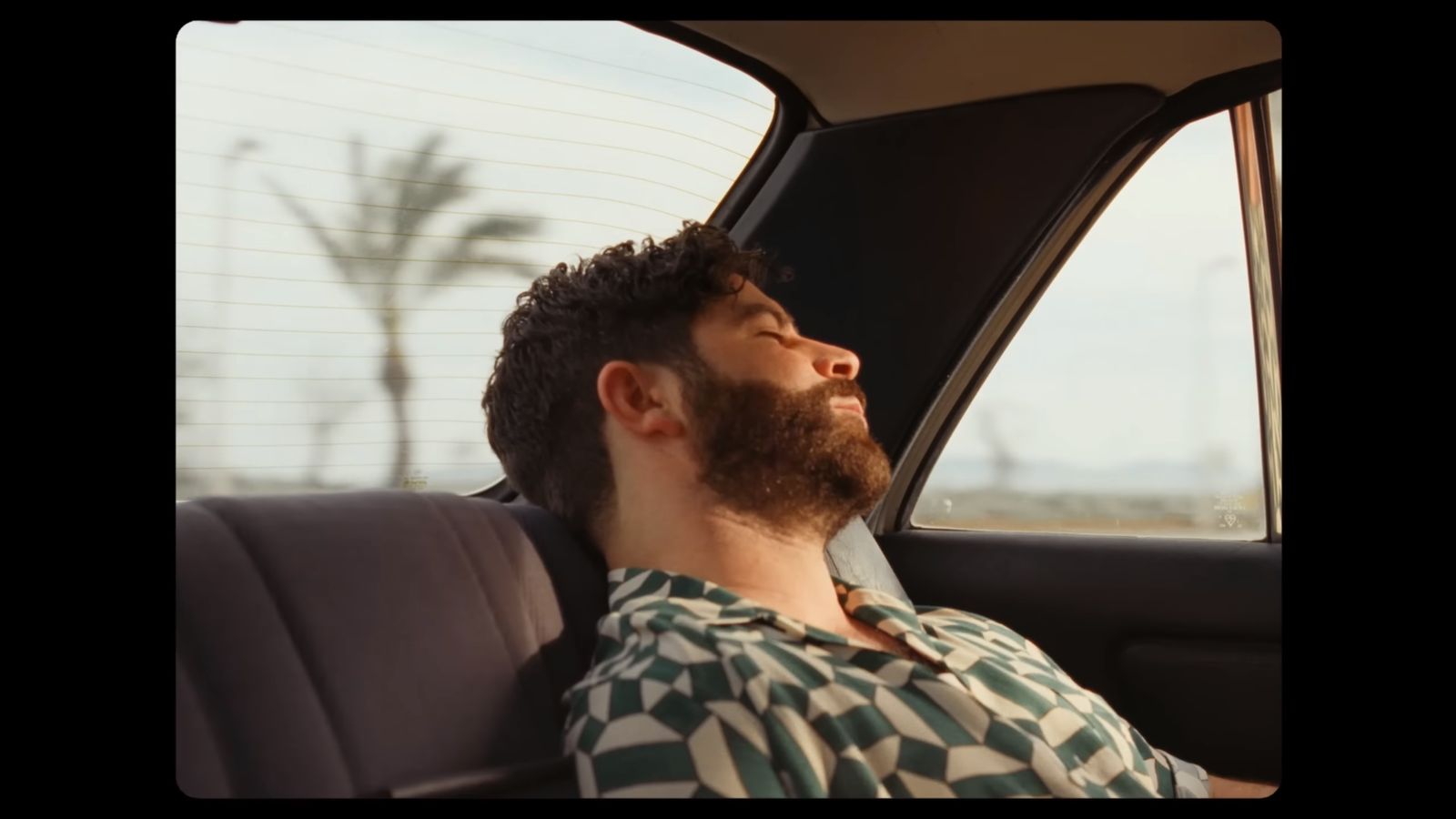 a man with a beard sitting in a car