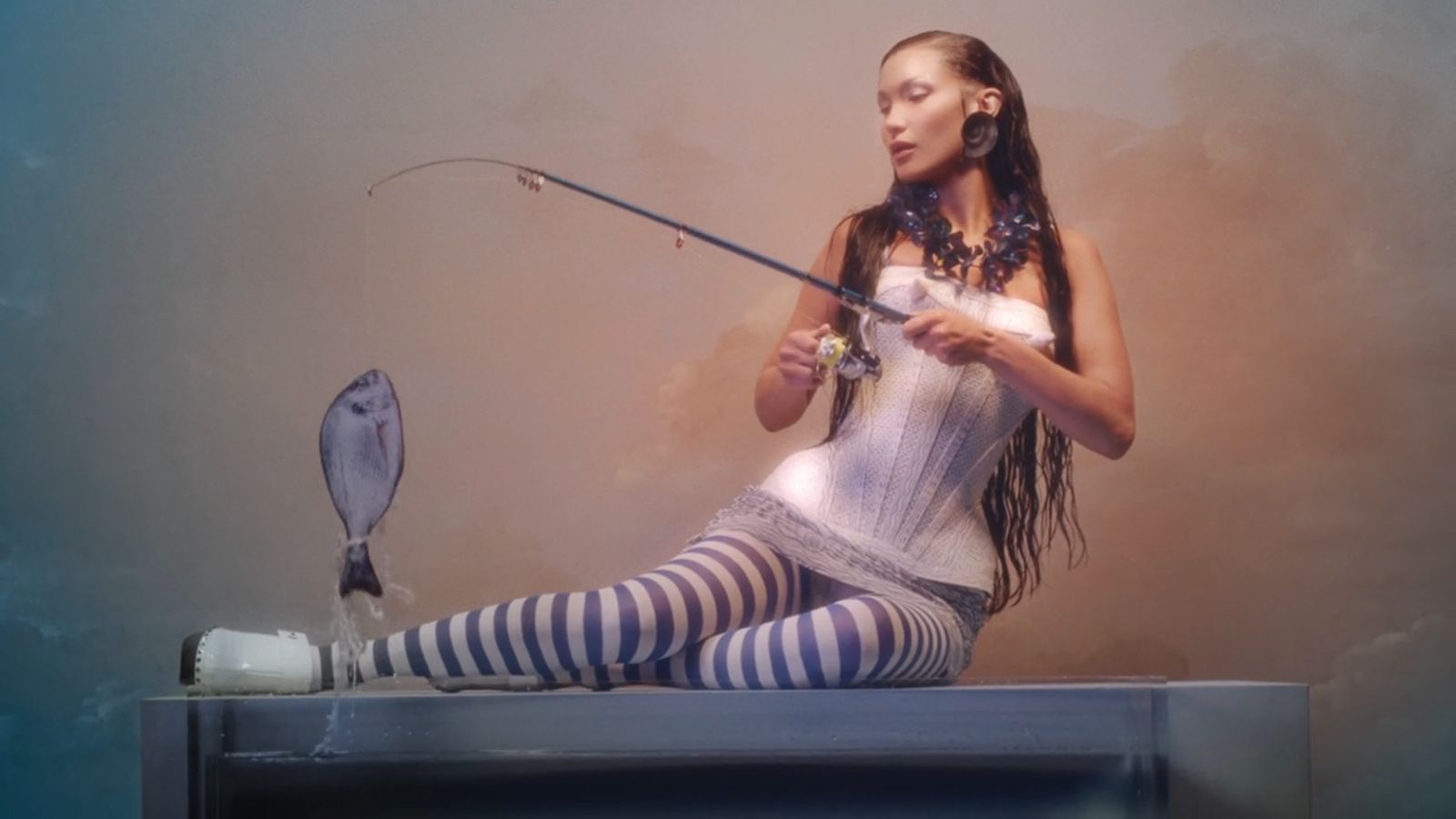 a woman sitting on top of a table holding a fish