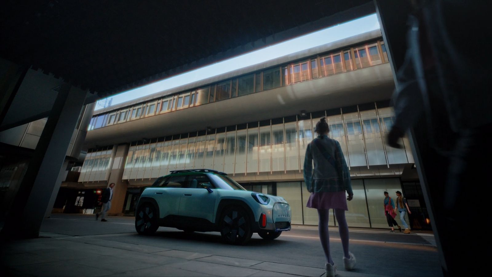 a person standing next to a car in front of a building