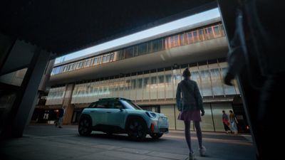 a person standing next to a car in front of a building