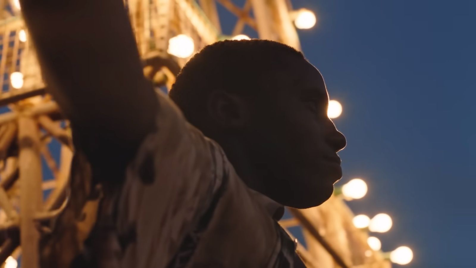 a close up of a statue of a man in front of a ferris wheel