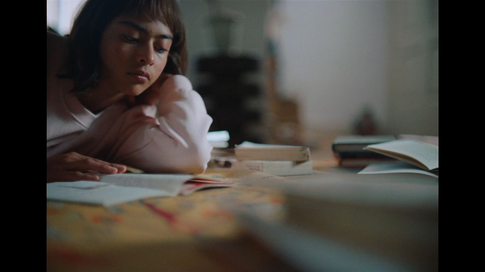 a woman sitting at a table reading a book