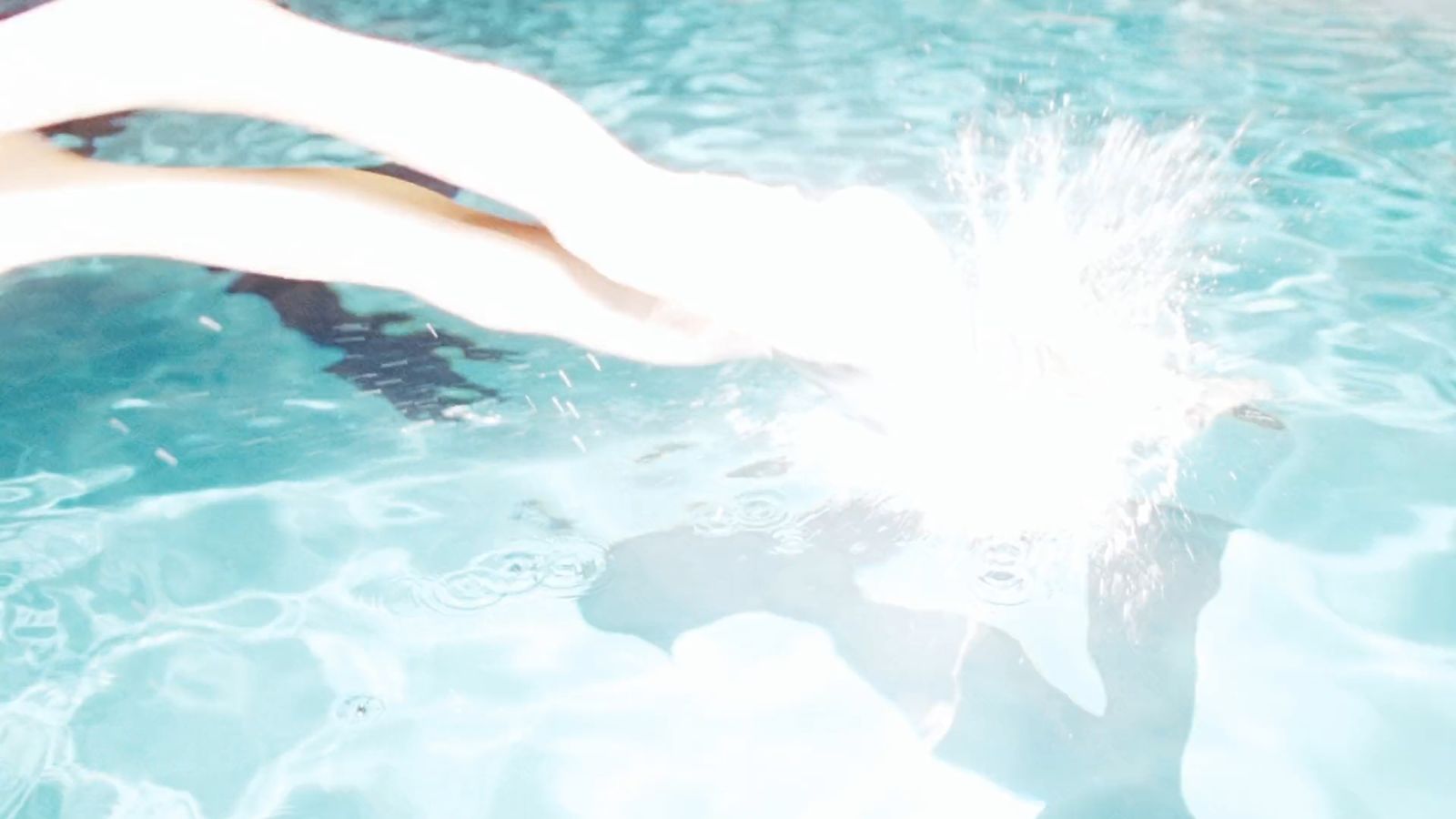 a person in a swimming pool throwing a frisbee