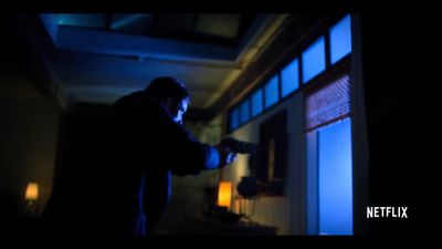 a man holding a gun in a dark room