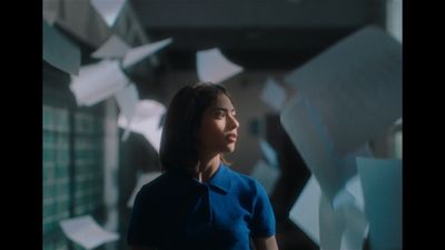 a woman standing in front of a bunch of papers