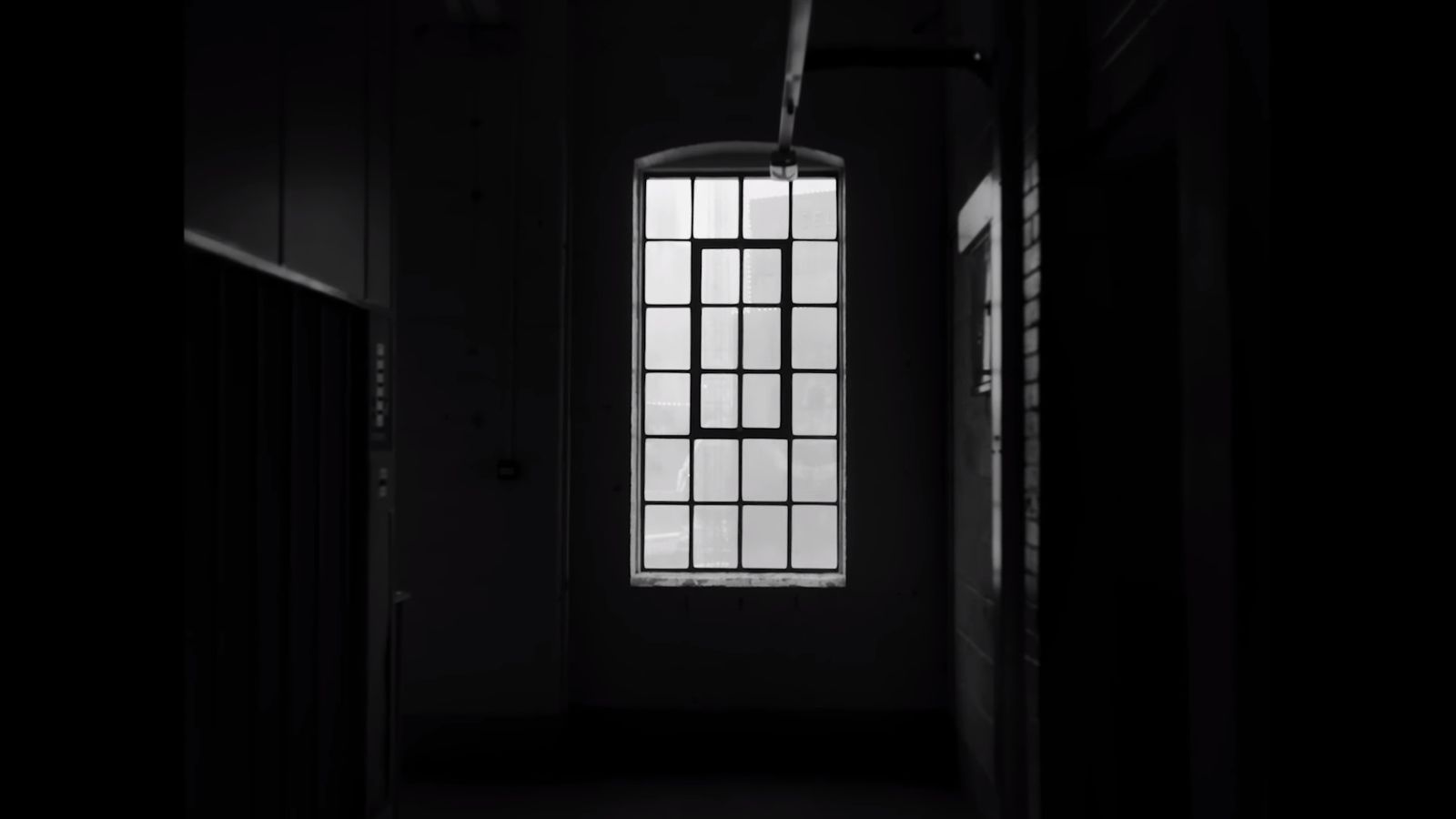 a dark hallway with a light coming through the window