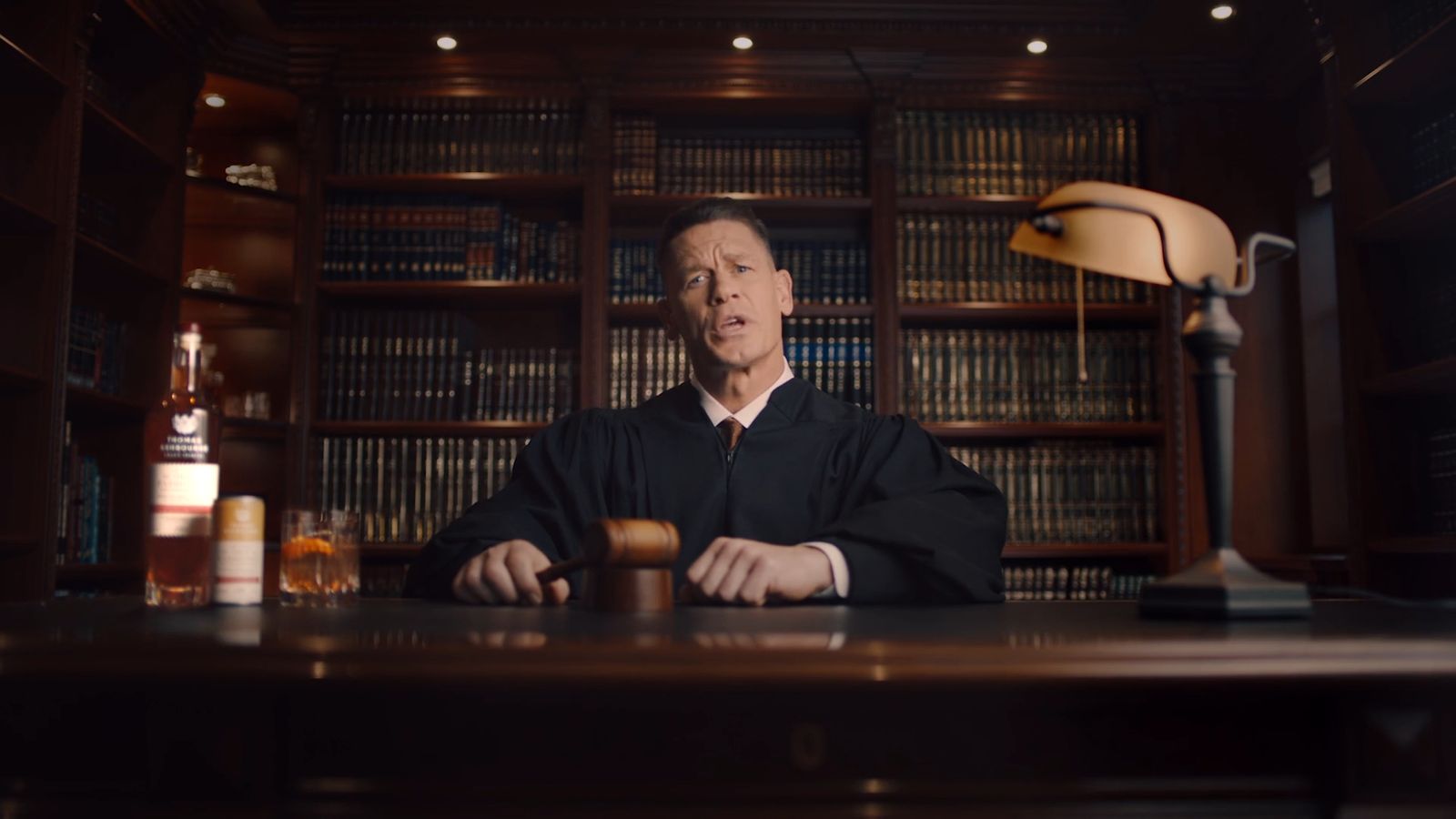 a man sitting at a desk in front of a book shelf