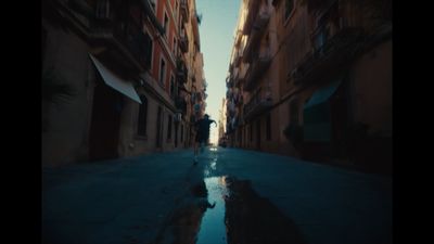 a person walking down a street next to tall buildings