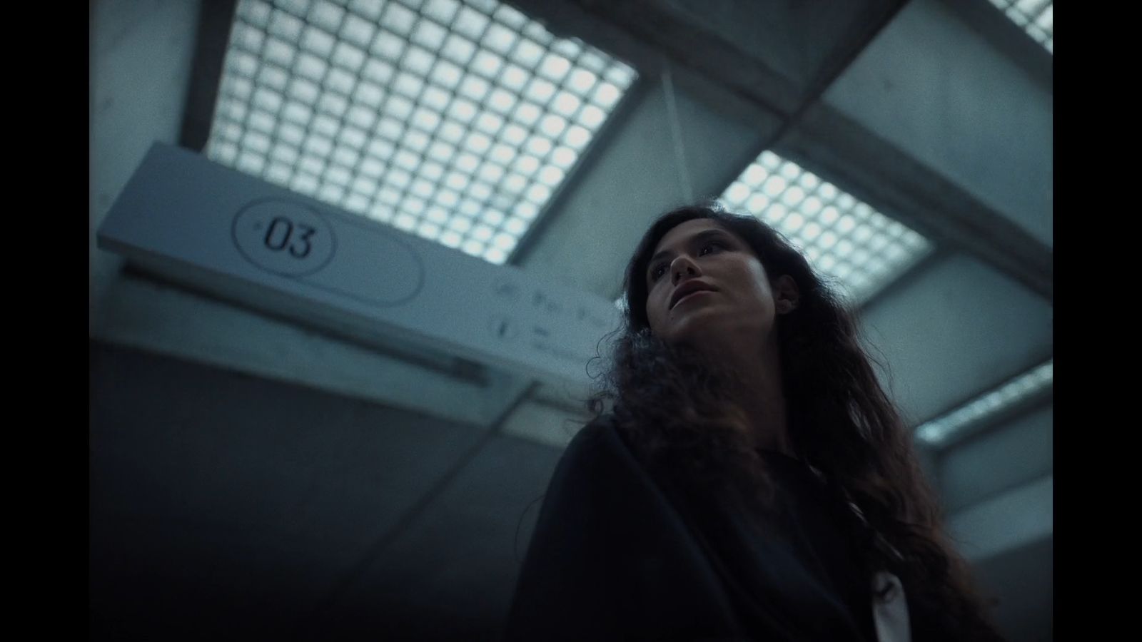 a woman standing in a building looking up at the sky