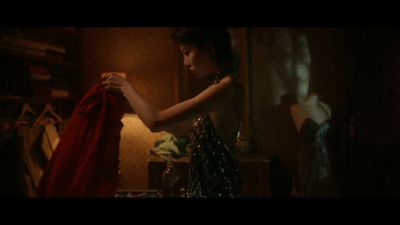 a woman standing in a room holding a red cloth