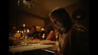 a woman sitting at a table looking at her cell phone