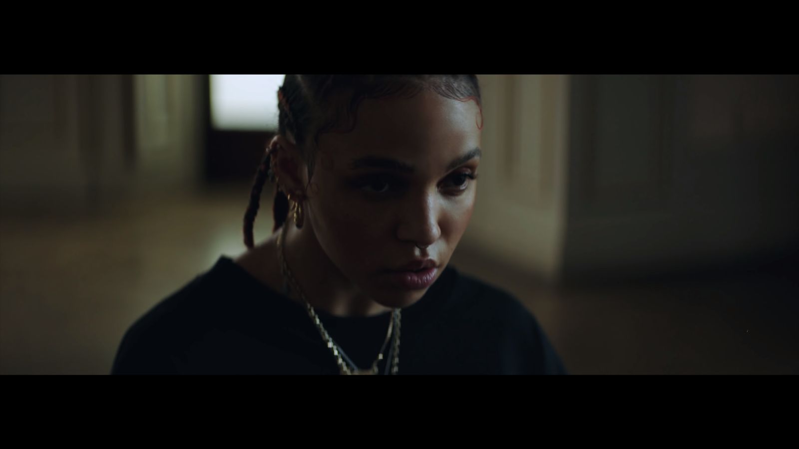 a woman with dreadlocks is staring at the camera