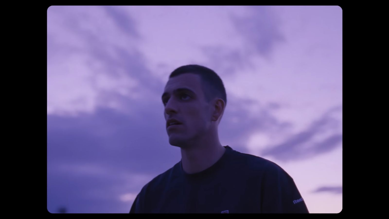 a man standing in front of a cloudy sky