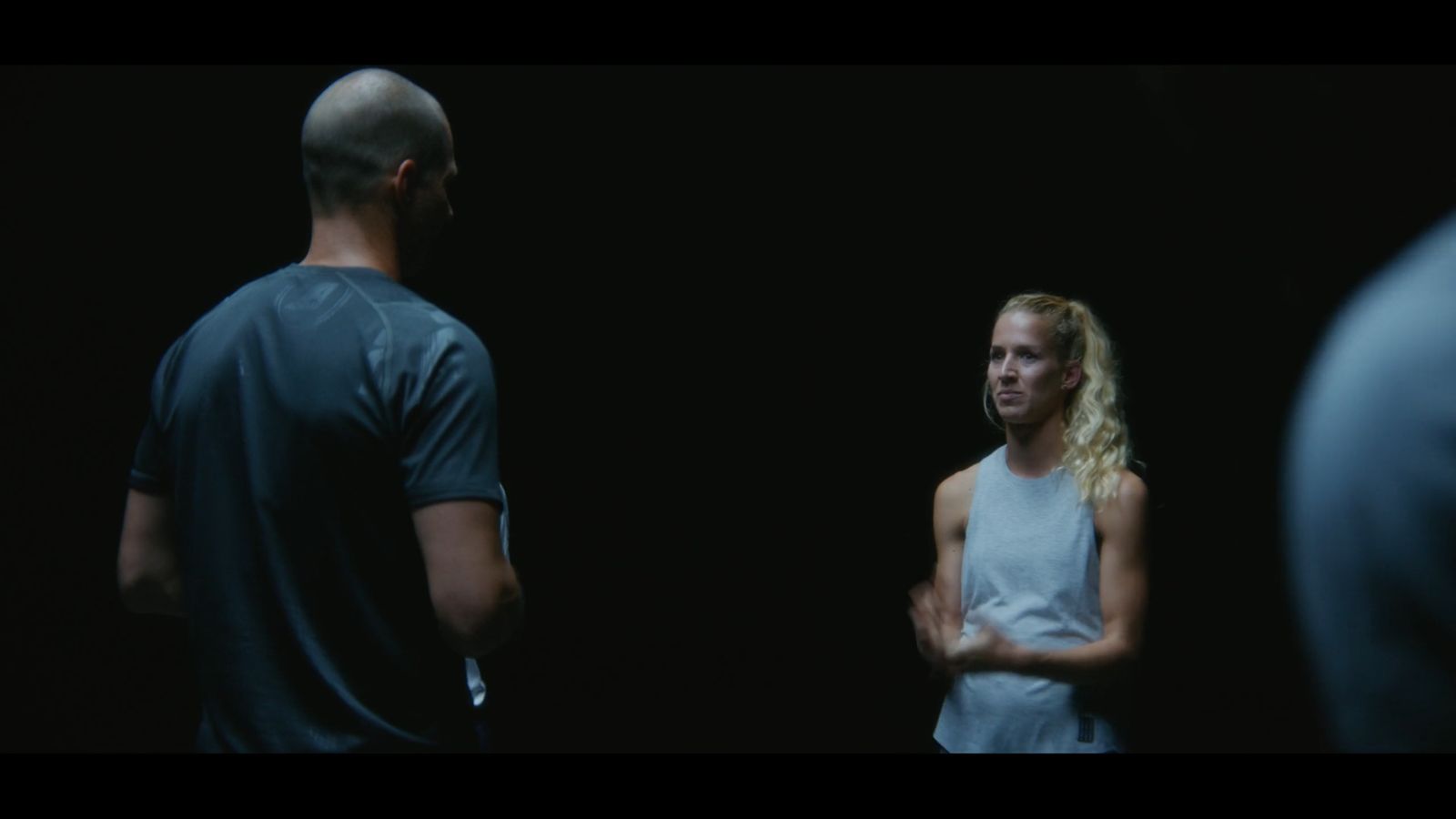 a man standing next to a woman in a dark room