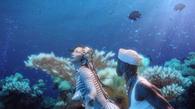 a couple of people standing in front of a fish tank