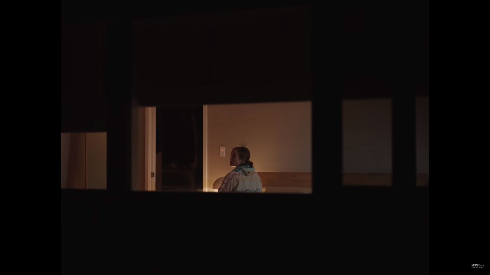 a person standing in a dark room looking out a window