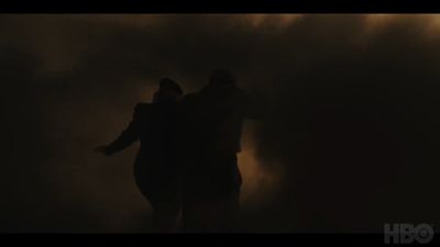 two people standing in the dark with their arms around each other