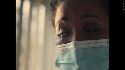 a woman wearing a surgical mask looking at the camera