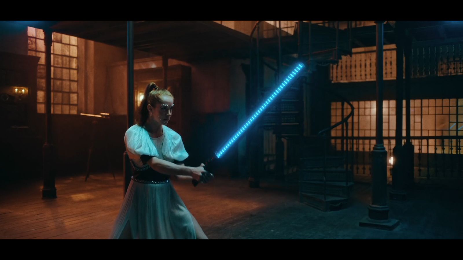 a woman in a white dress holding a light saber