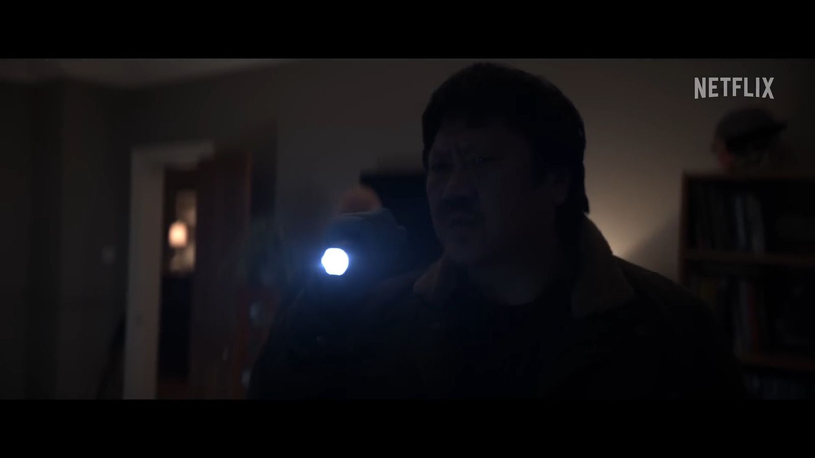 a man standing in a room with a flashlight