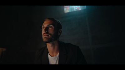 a man standing in a dark room with his eyes closed