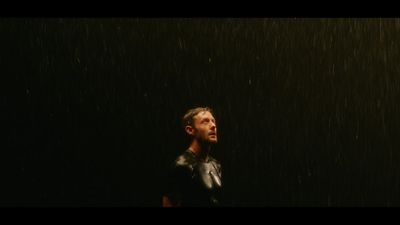 a man standing in the rain in the dark