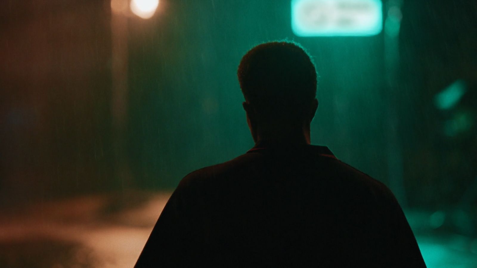 a man standing in the rain at night