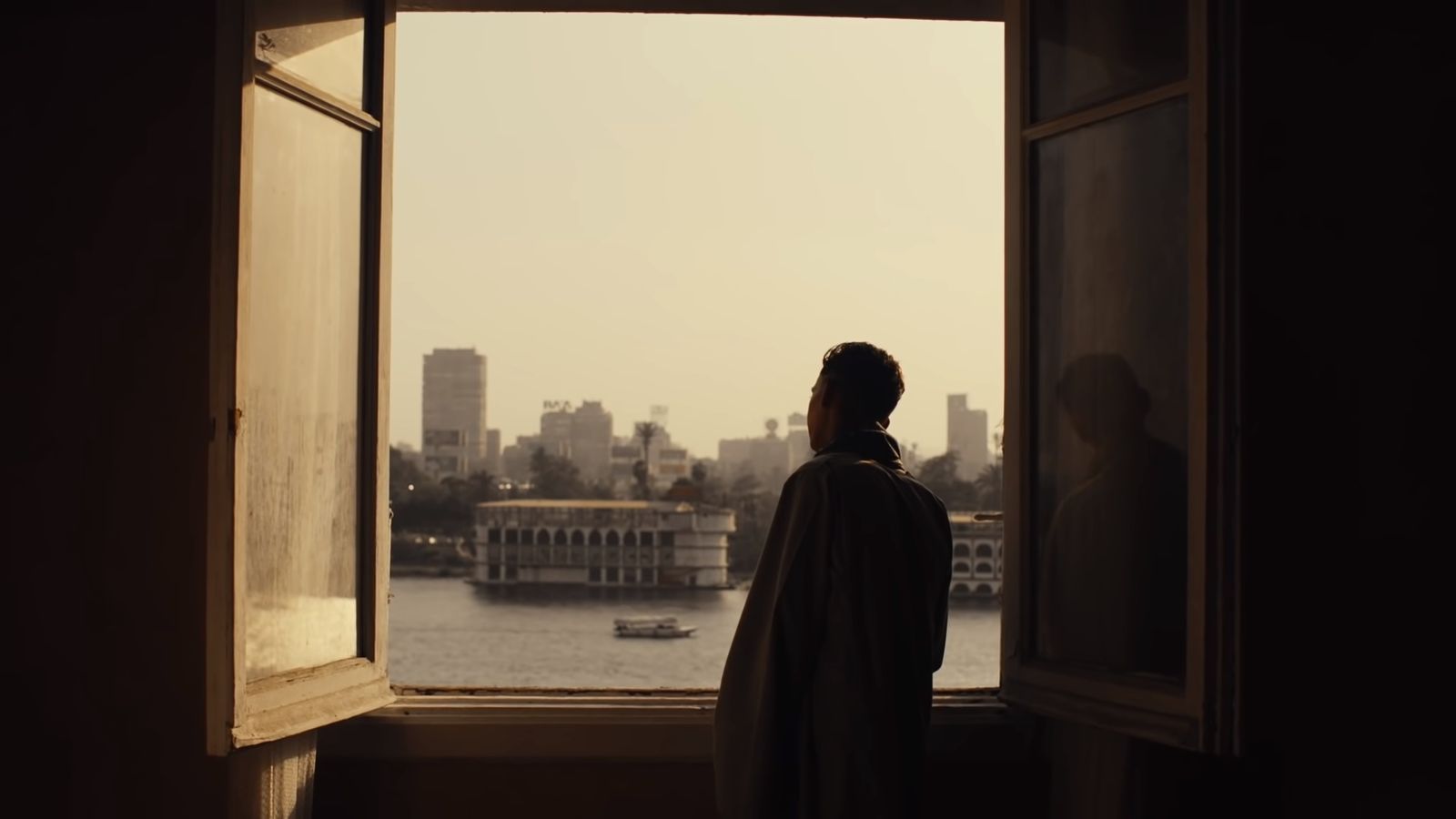 a person looking out a window at a body of water