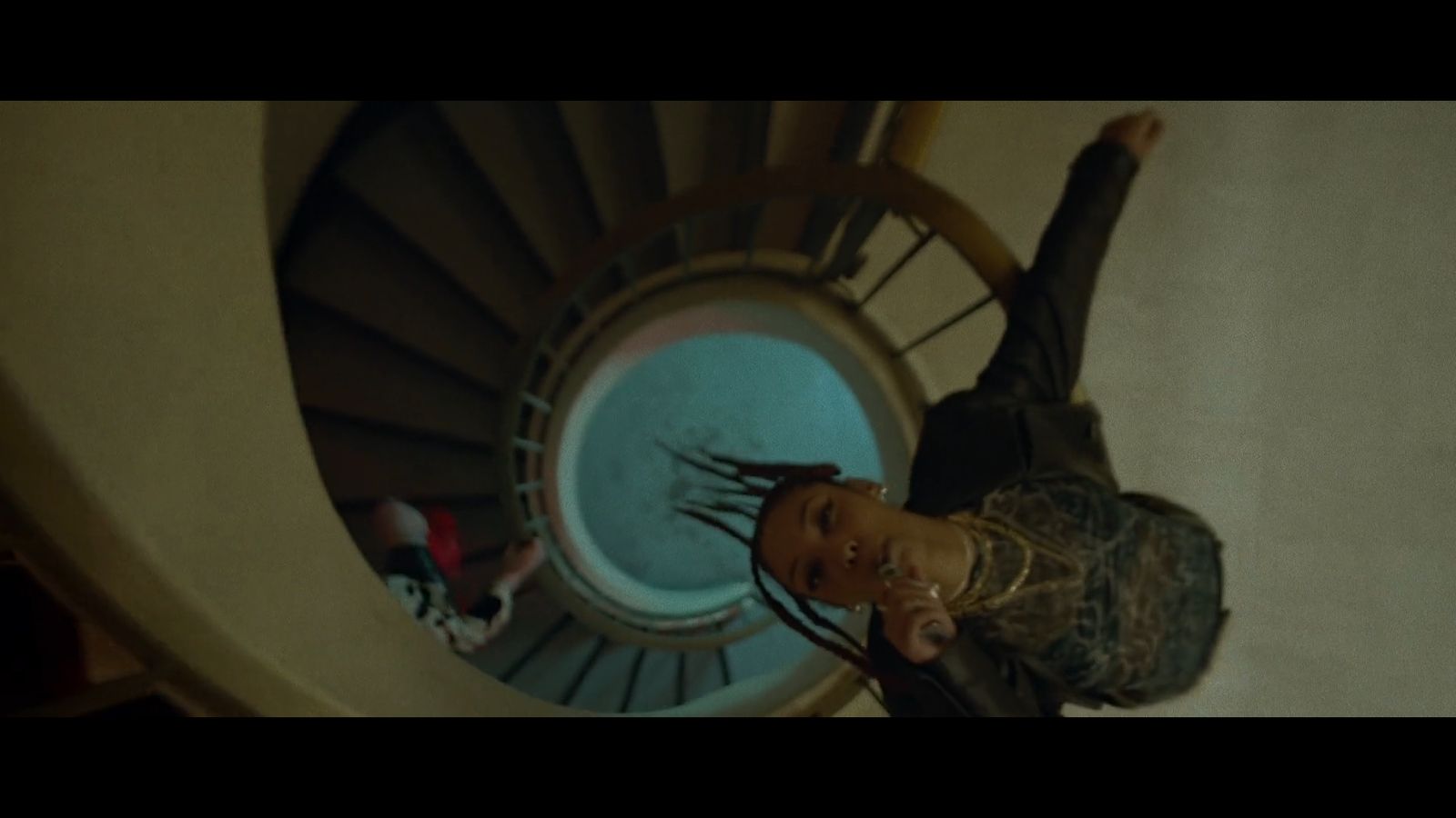 a woman standing in front of a spiral staircase