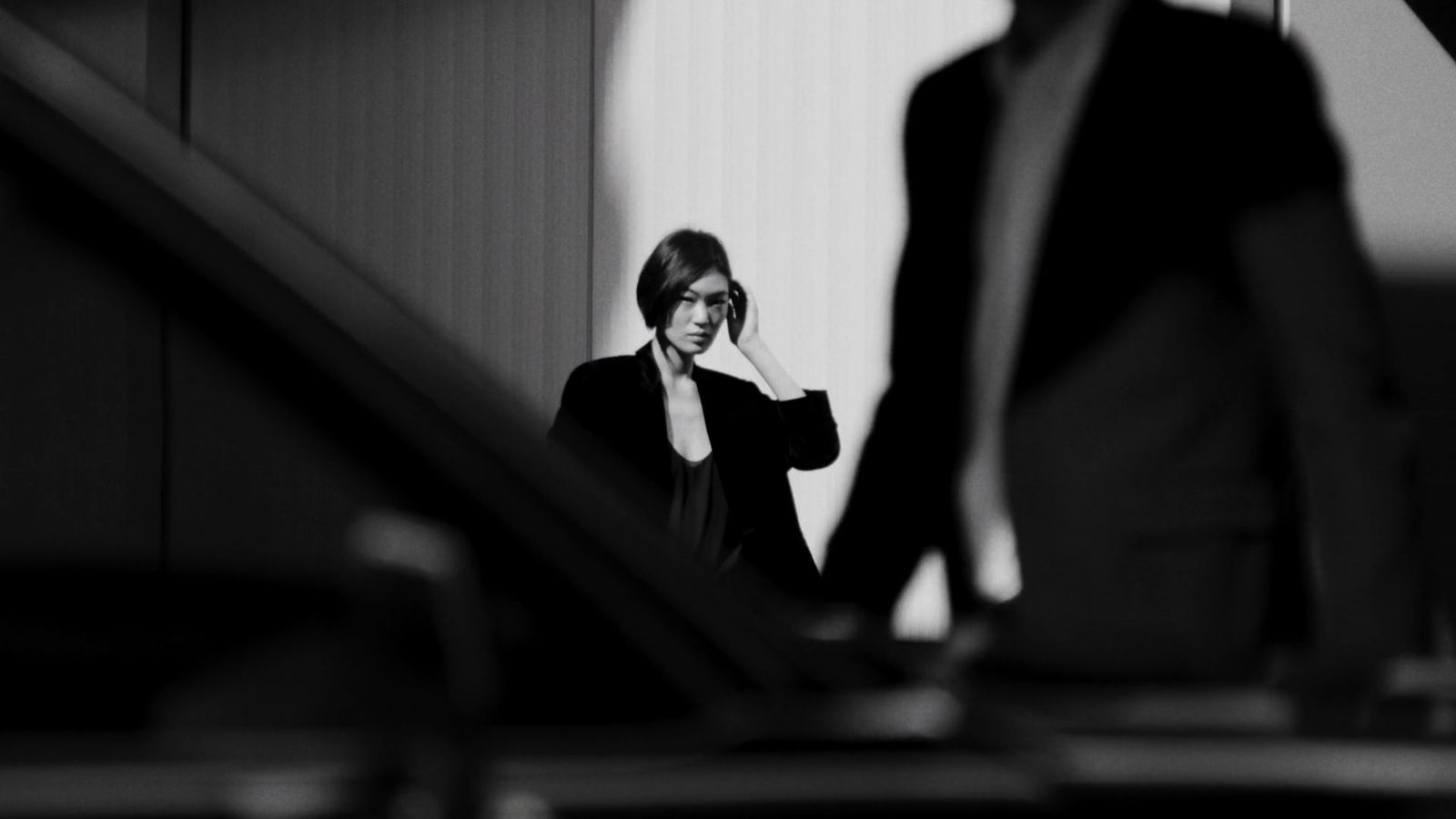 a woman standing next to an escalator talking on a cell phone