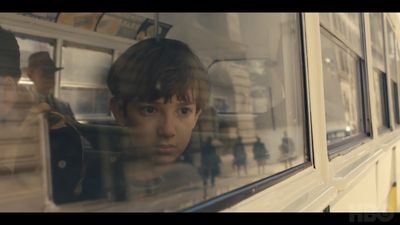 a boy looking out the window of a bus