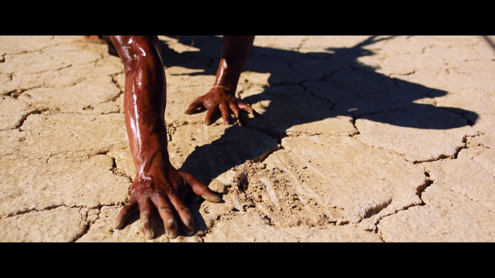 a person covered in mud reaching for something