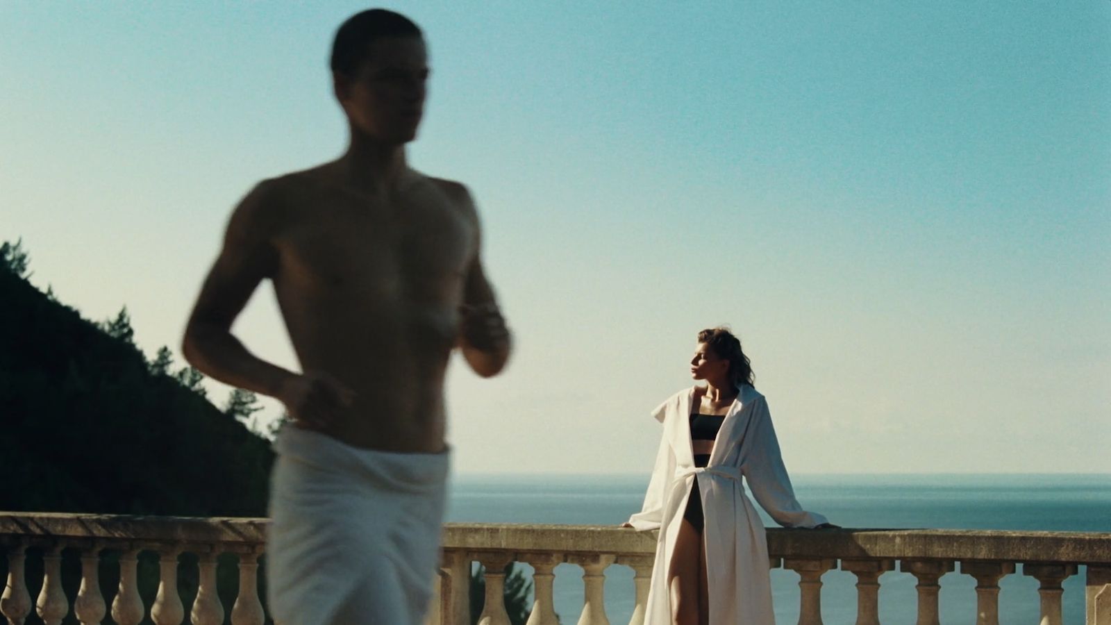 a man and a woman standing next to each other on a balcony