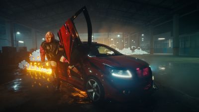 a man standing next to a car in a garage