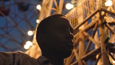 a man standing in front of a ferris wheel