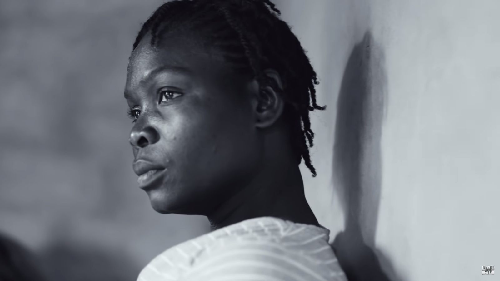 a black and white photo of a woman with dreadlocks