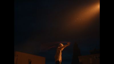 a person standing under a street light holding a kite