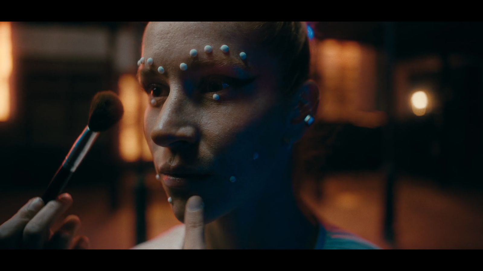 a woman with piercings on her face holding a brush