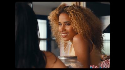 a woman with curly hair looking at another woman