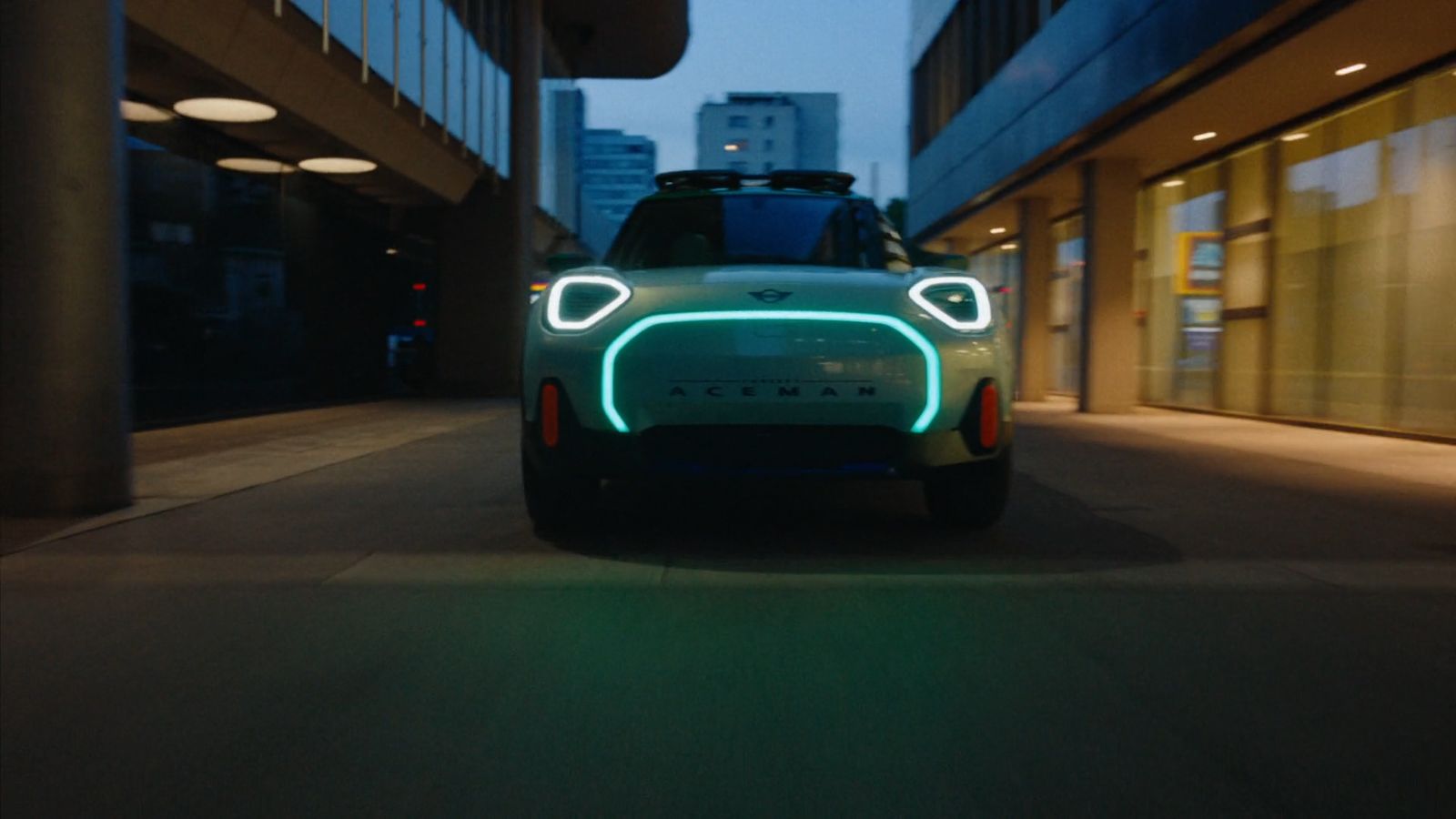 a green car is driving down a city street