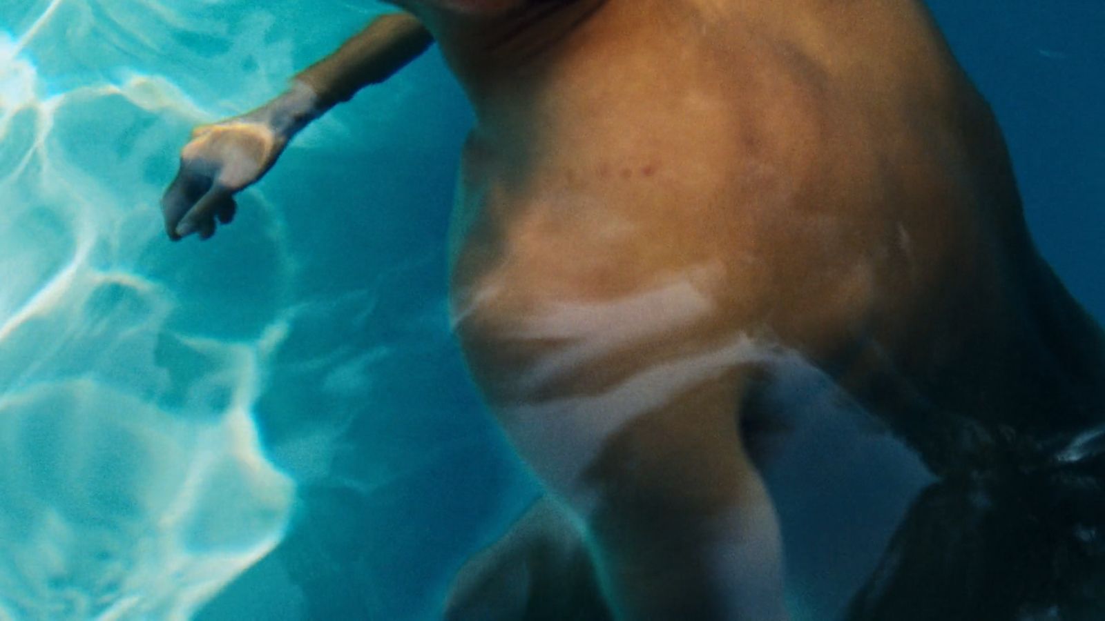 a man swimming under water in a pool