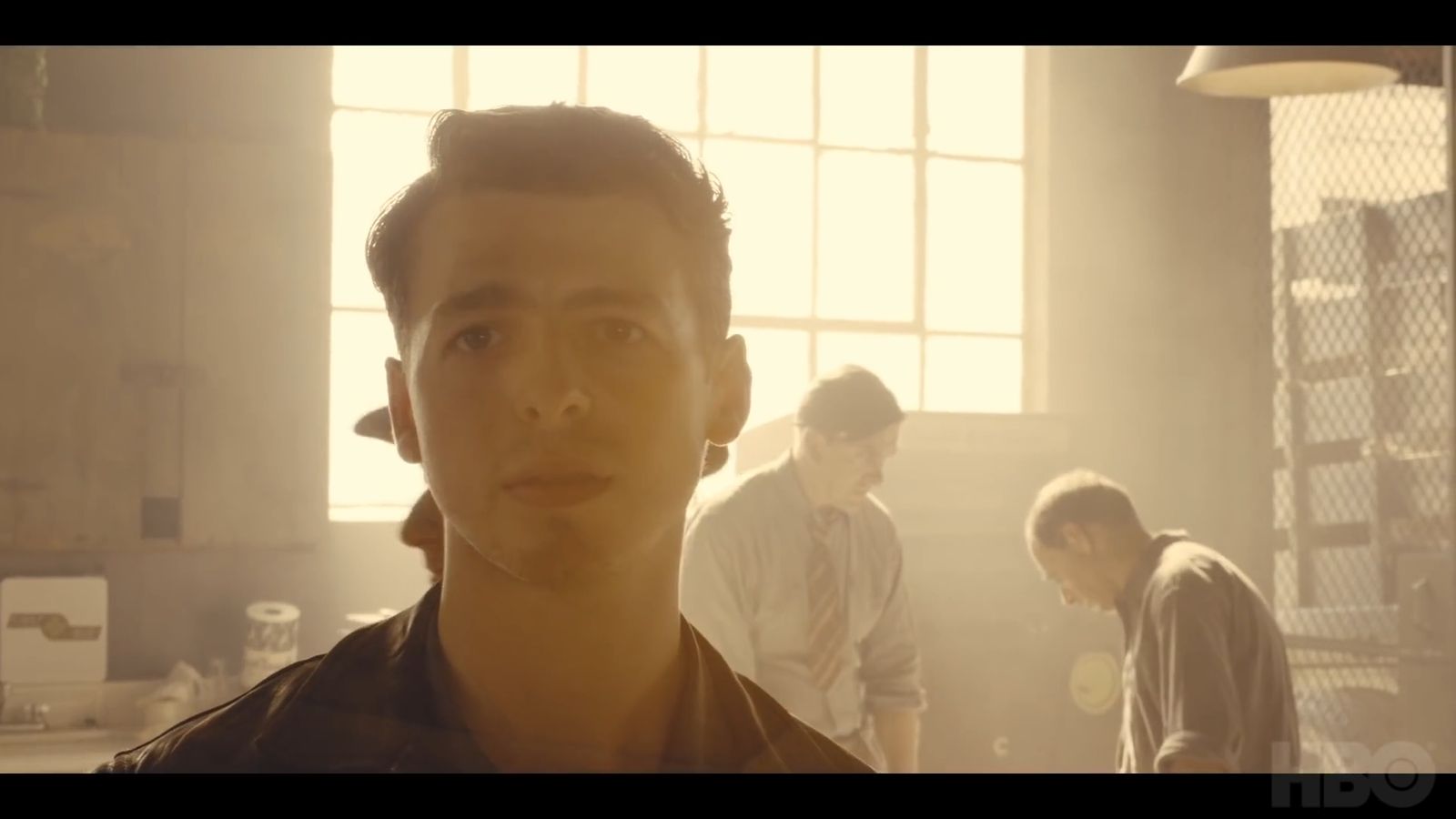 a group of young men standing around a kitchen