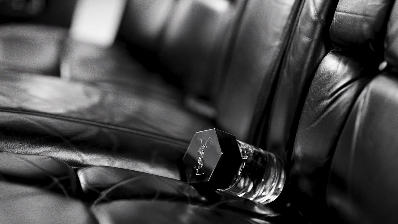 a glass bottle sitting on top of a leather couch