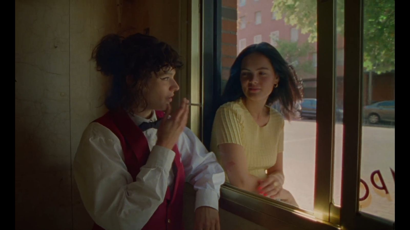 a woman standing next to a man looking out a window