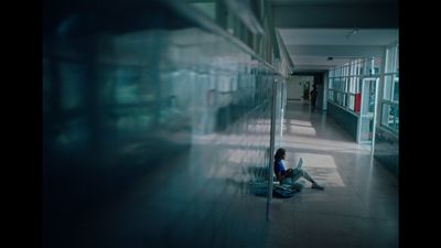 a person sitting on the floor in a hallway