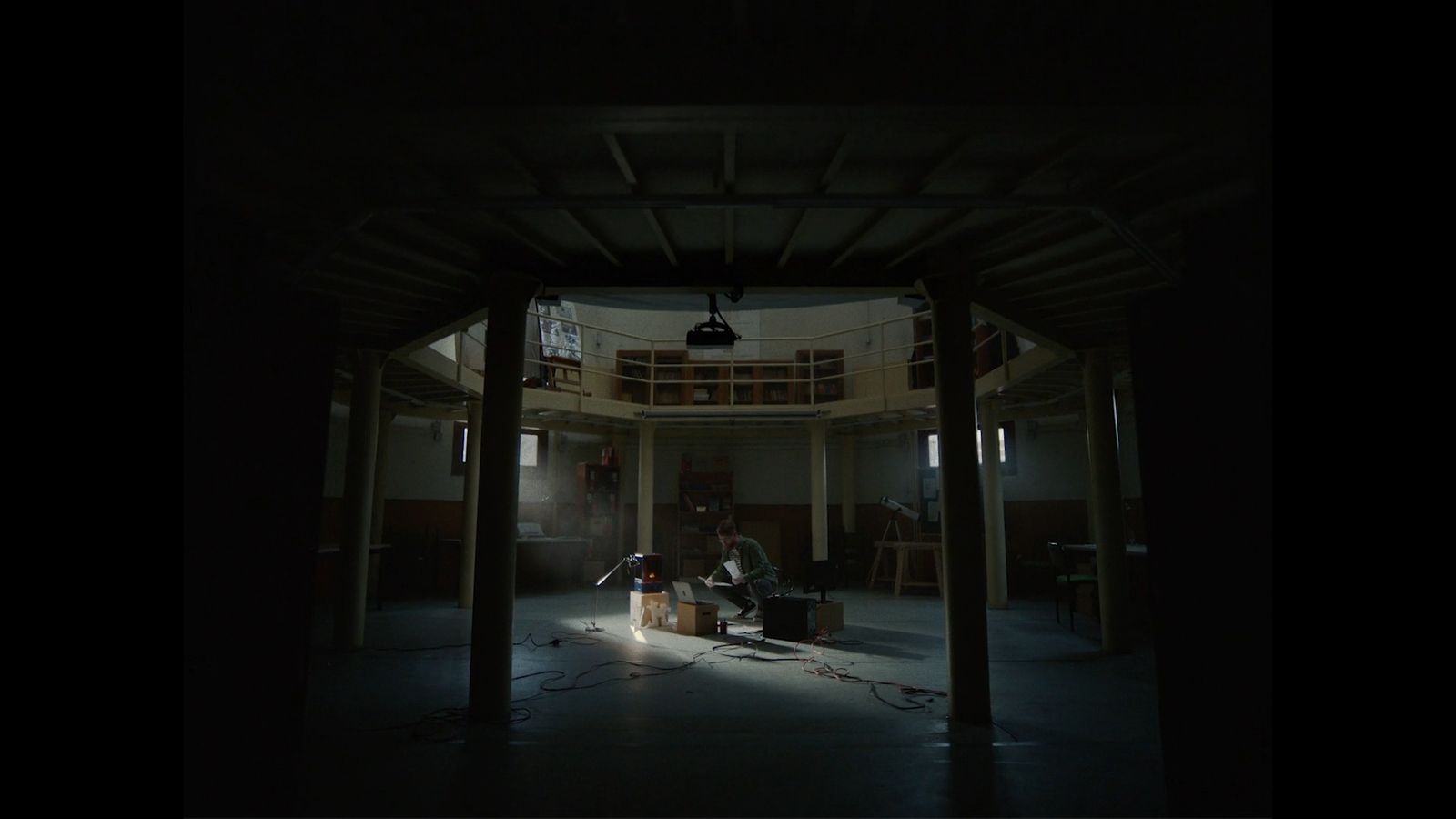 a dark room with a person sitting in a chair