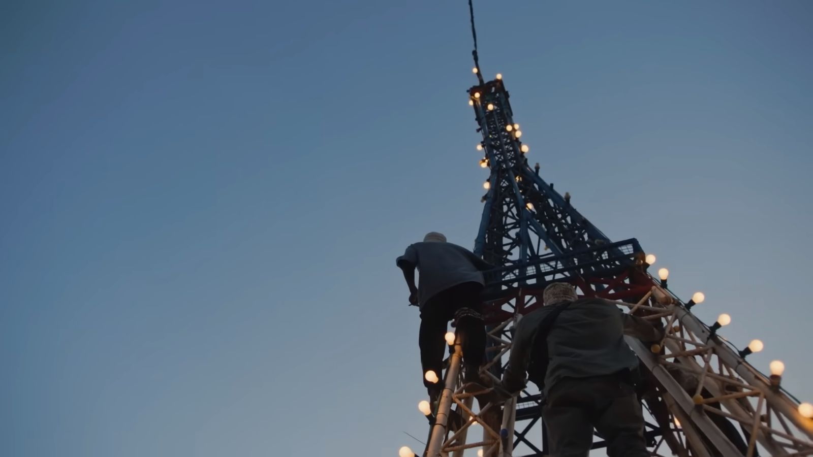 two men working on the top of the eiffel tower